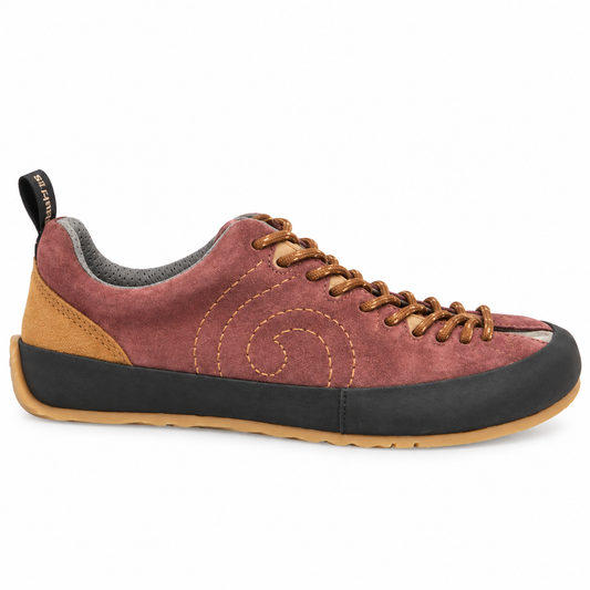 A single low-top shoe shown in profile against a white background. The upper is made of dusty rose suede with a tan heel panel, brown laces, a black outsole, and a tan rubber toe bumper and midsole edge.